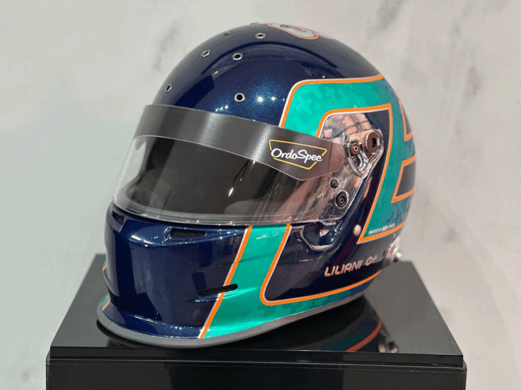 Design de capacete minimalista: Capacete com pintura em azul escuro e verde e detalhes com linhas laranja e branco